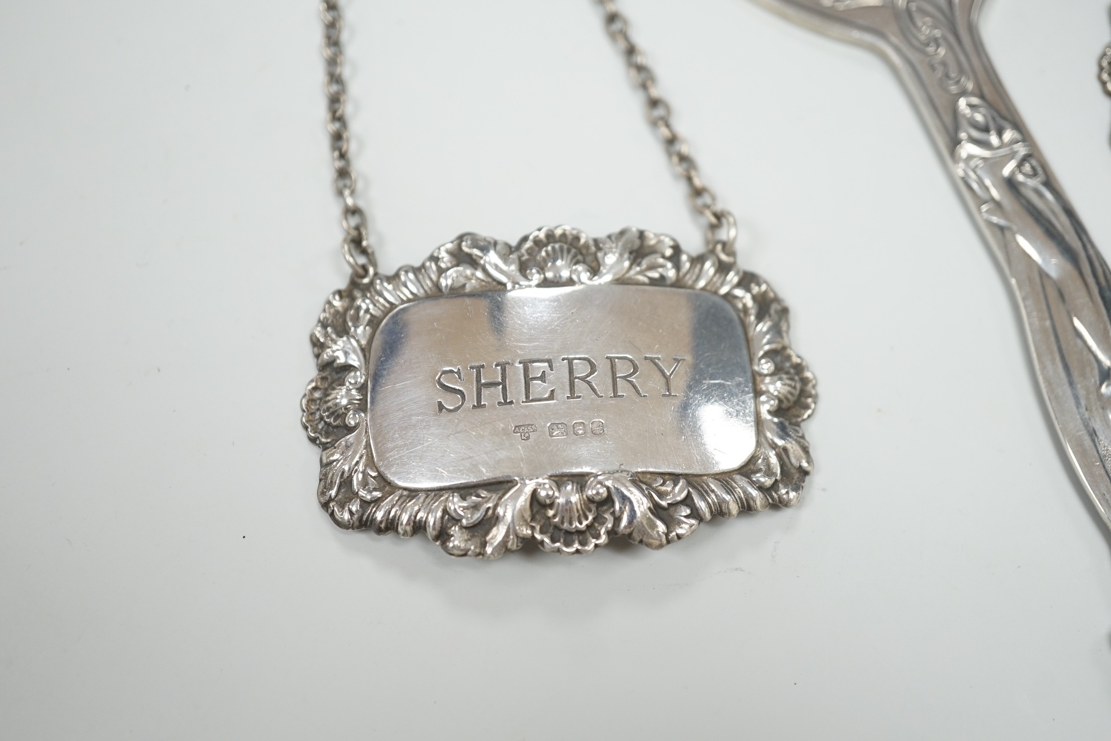 A pair of Queen Elizabeth II silver wine labels, 'Sherry & Brandy', A. Chick & Sons, Ltd, London, 1975 and an Art Nouveau style silver plated bottle opener.